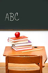 Image showing Old school desk with a stack of books