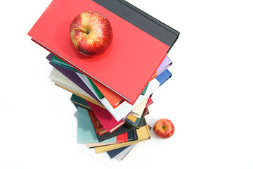 Image showing Large piles of books with apples on white