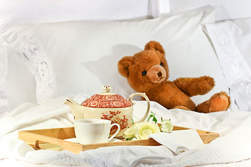 Image showing Tea in bed with teddy on white sheets