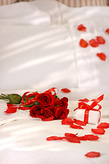 Image showing Red roses on a bed