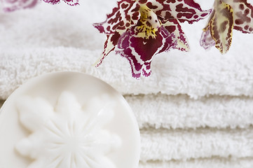 Image showing Spa items with white towels, natural soap and orchid