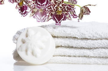 Image showing Spa items with white towels, natural soap and orchid