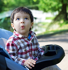 Image showing surprised tot peers into sky