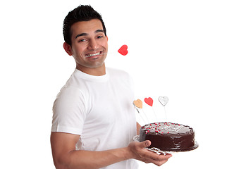 Image showing Man holding delicious chocolate cake decorated with love hearts