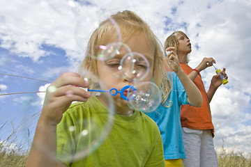 Image showing Childrem blowing bubbles