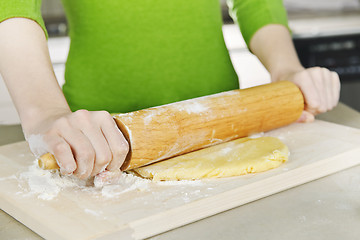 Image showing Hands with rolling pin and cookie dough