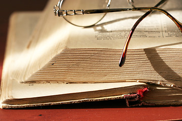 Image showing aging book and spectacles for correcting the vision