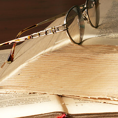 Image showing aging book and spectacles for correcting the vision