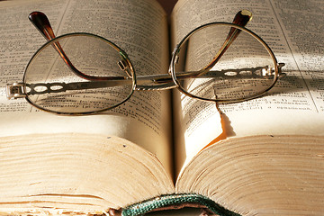 Image showing aging book and spectacles for correcting the vision