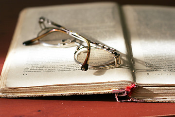 Image showing aging book and spectacles for correcting the vision