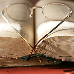 Image showing aging book and spectacles for correcting the vision