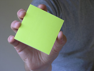 Image showing Hand holding balnk note pad, yellow.