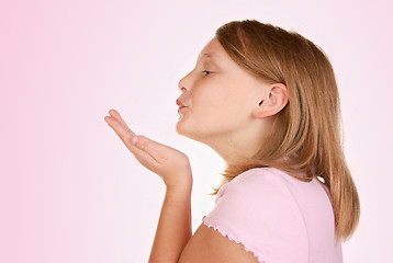 Image showing young girl blowing a kiss on pink