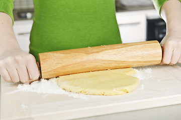 Image showing Hands with rolling pin and cookie dough