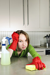 Image showing Tired girl cleaning kitchen