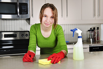 Image showing Young woman cleaning kitchen