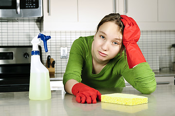 Image showing Tired girl cleaning kitchen