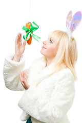 Image showing Woman in rabbit costume stretch out for carrot