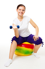 Image showing Young woman doing exercises with ball and dummbell