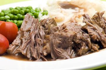 Image showing   sliced pot roast beef dinner with peas mashed potatoes and gravy