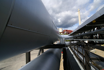 Image showing industrial pipelines on pipe-bridge against blue sky