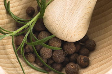 Image showing Mortar with fresh herbs and allspice berries