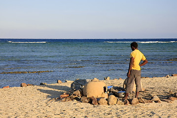 Image showing Egyptian man cooking dinner on the beach