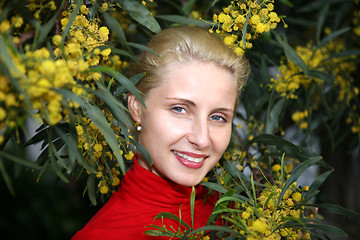 Image showing young female face bordered by bright yellow mimosa flowers