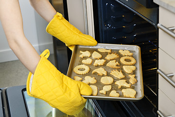 Image showing Taking cookies from oven