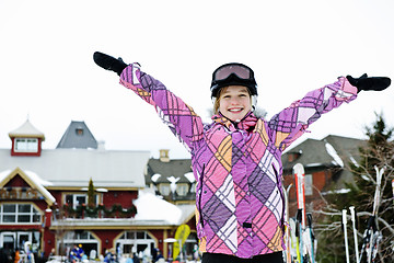 Image showing Happy girl with arms raised at resort