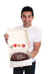 Image showing Adult man holding a chocolate birthday cake