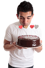 Image showing Romantic man kissing heart on a cake