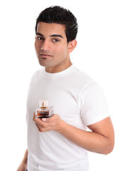 Image showing Adult male holding a bottle of aftershave or men's fragrance