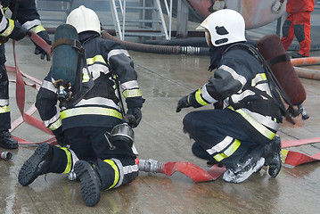 Image showing Fire fighters preparing hoses