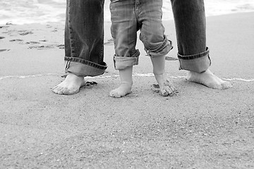 Image showing feet of father and child by sea