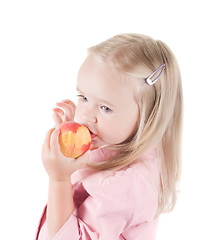 Image showing Little girl eating peach in studio