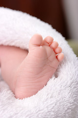 Image showing Adorable toddler's foot on white blanket