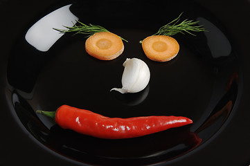 Image showing Cheerful Smiling face from vegetables on a black plate 