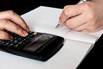 Image showing woman counting with a calculator