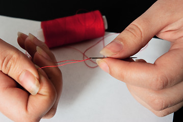 Image showing woman threading a needle