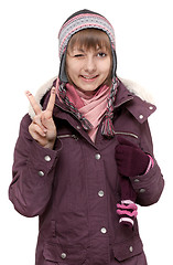 Image showing Young beautiful girl in winter to jacket and hat shows Ok