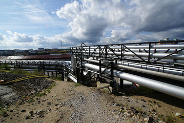 Image showing industrial pipelines on pipe-bridge against blue sky