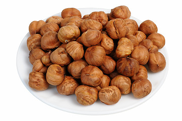 Image showing Hazelnuts on a white plate, isolated.