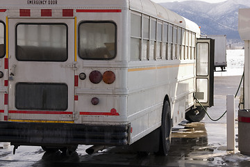 Image showing White School Bus Pumping Gas