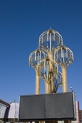 Image showing Four Metal Umbrellas with a Blank Billboard in front of it