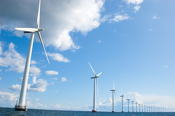 Image showing Windmills lined up in the sea, close