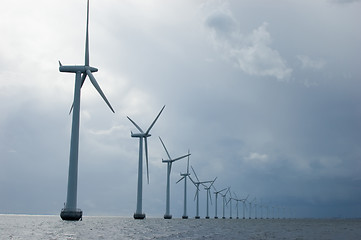 Image showing Windmills in a row on cloudy weather, close