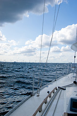 Image showing Sailing boat and windmills on sunny day, vertical