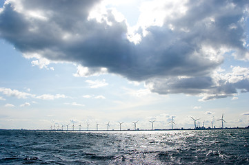 Image showing Clouds on blue sky over windmill farm