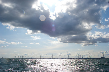 Image showing Clouds on blue sky with lens flare over windmill